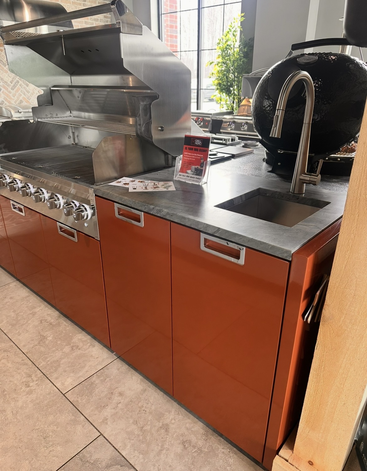 Crown Verity modular kitchen display with orange cabinets, grill and sink