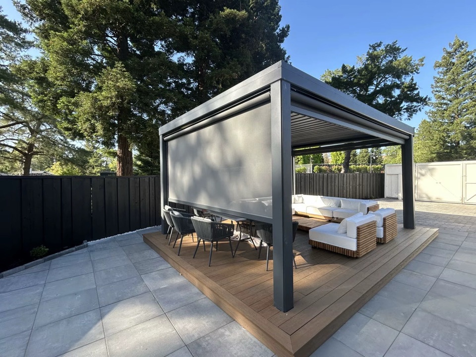 Louvered pergola with a lowered shade screen over outdoor lounge and dining seating